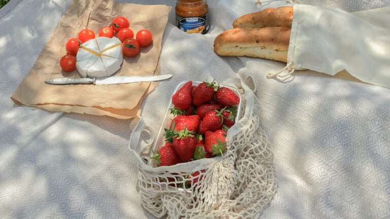 a picnic table with strawberries and bread