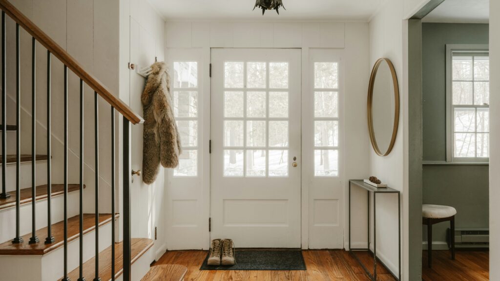 A cozy entryway with wooden stairs and a glass door