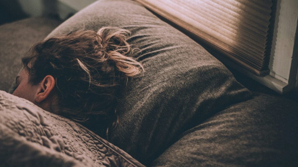woman sleeping on bed under blankets