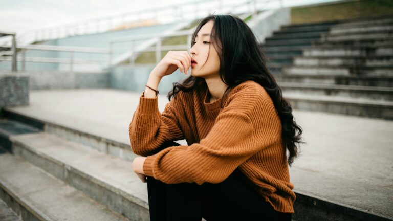woman wearing brown sweater holding lips