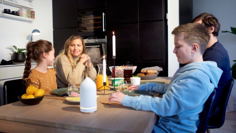 a group of people sitting around a wooden table