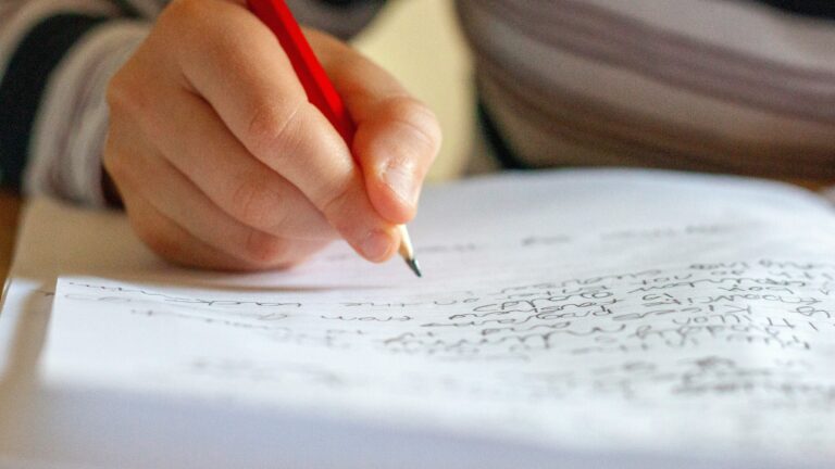 person writing on white paper