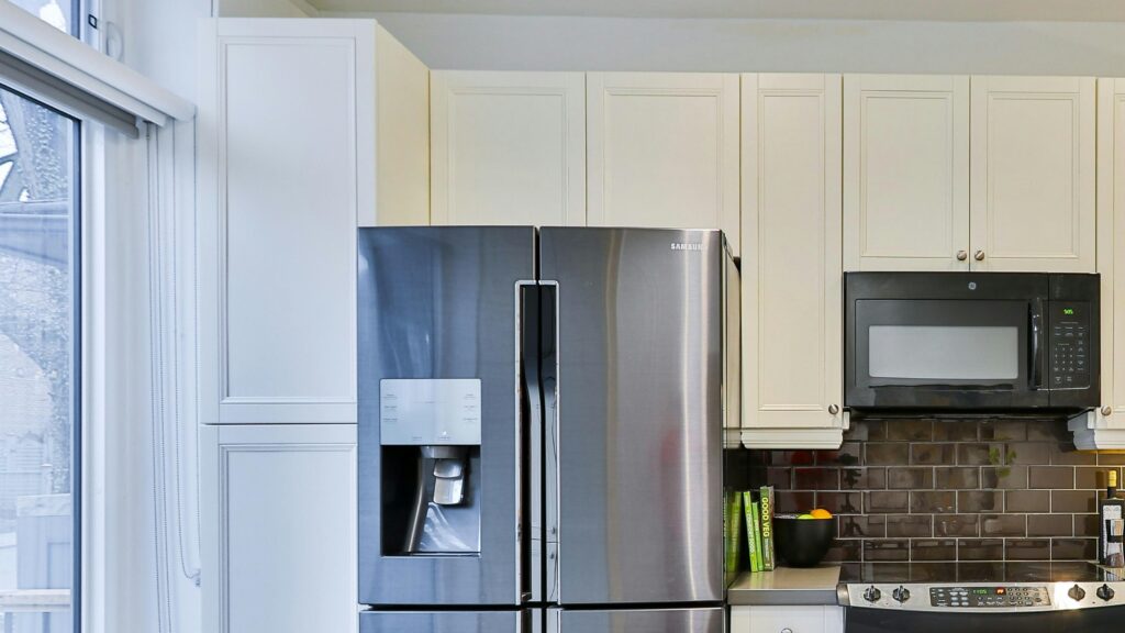silver french door refrigerator beside white wooden kitchen cabinet