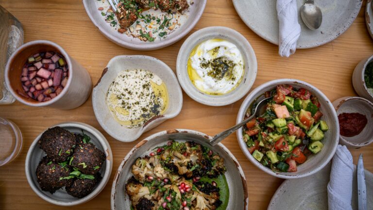 a wooden table topped with bowls of food
