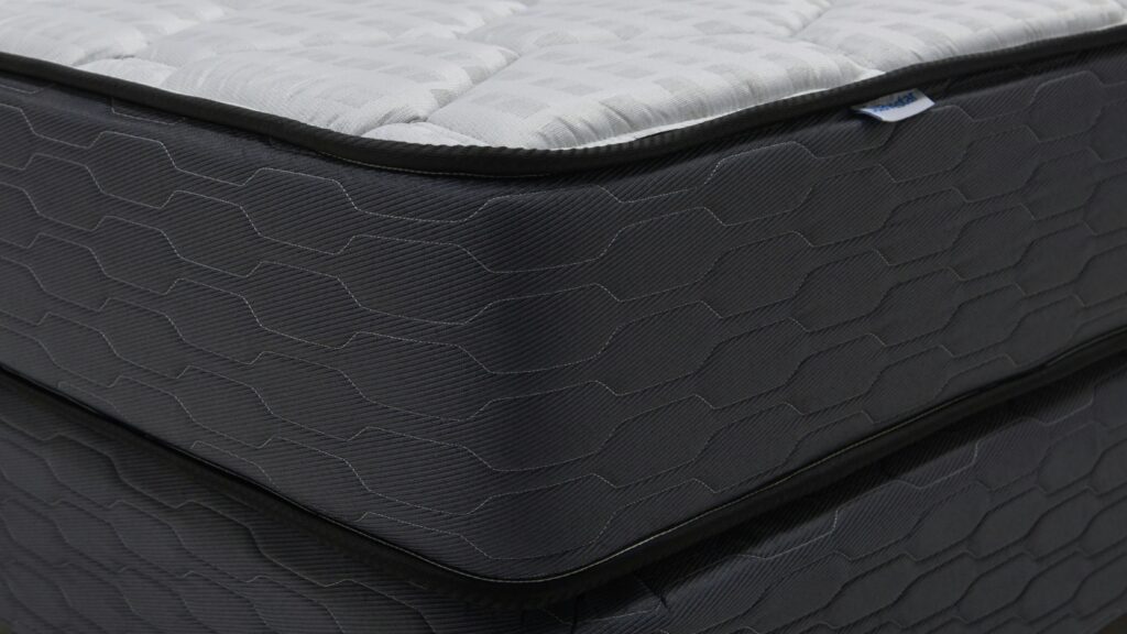 Close-up of a modern mattress with a dark patterned base