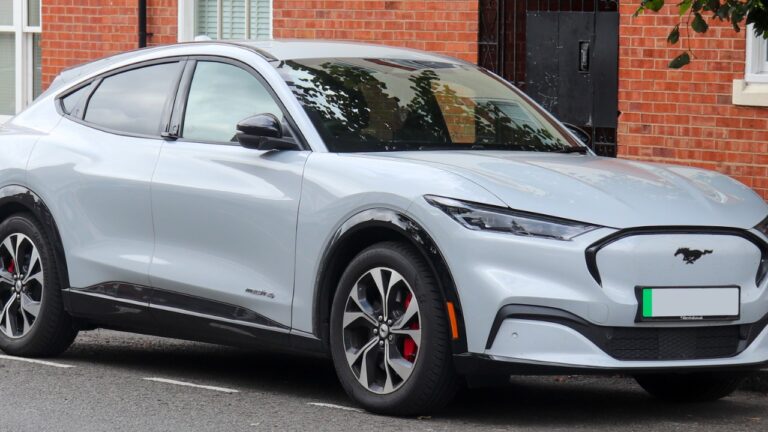 A silver Ford Mustang Mach-E electric SUV parked on a street