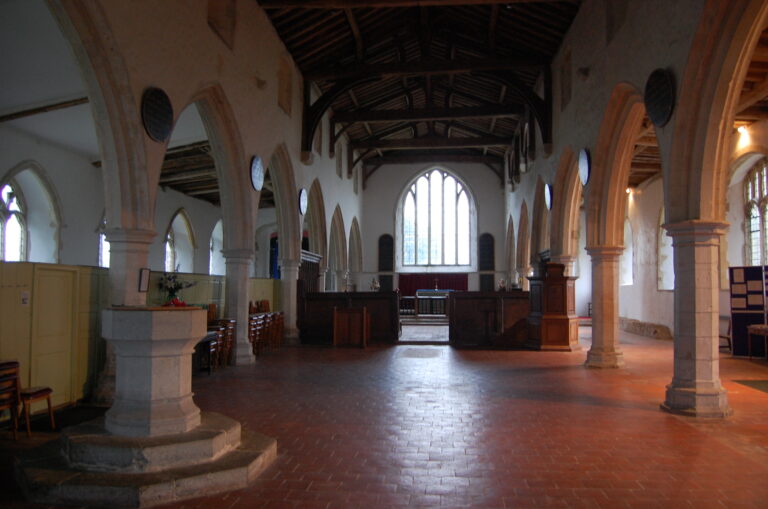 A quiet, empty church sanctuary interior with stone arches