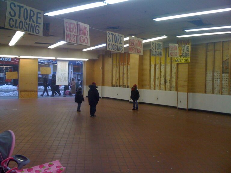 "Store Closing, Everything Must Go" signs hang in a shuttered mall storefront