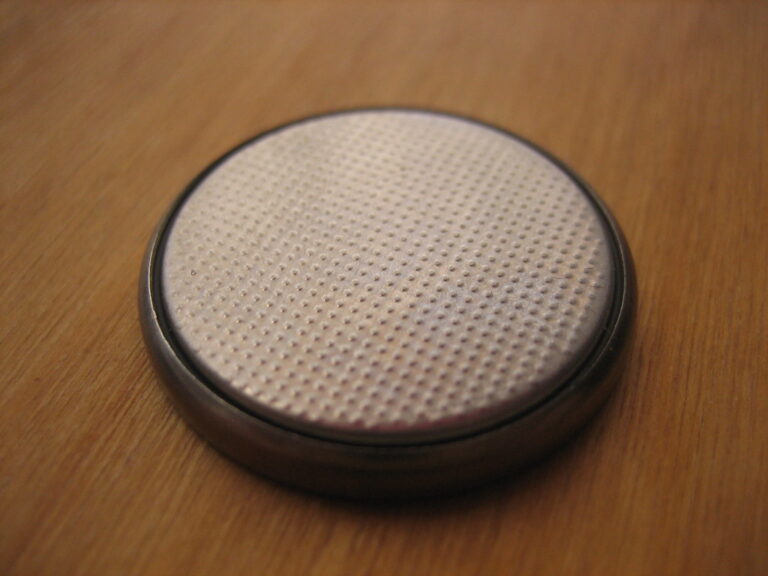 A button-cell battery on a wood surface