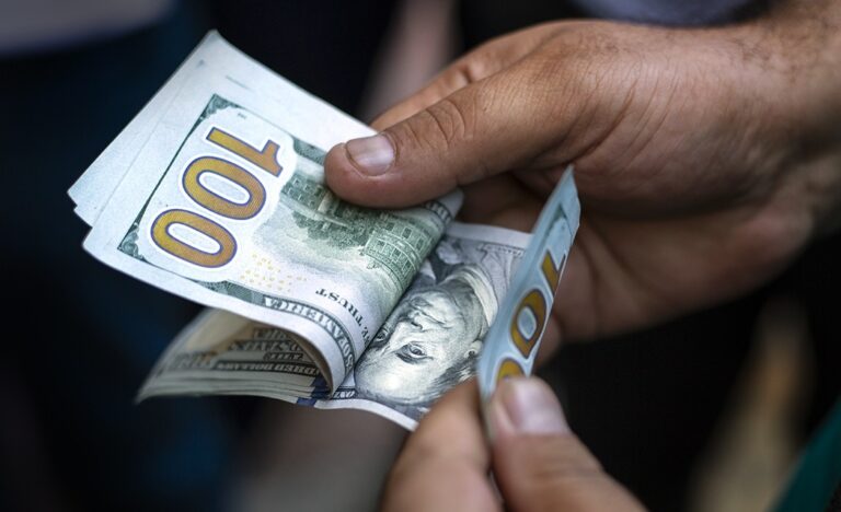 A hand counting U.S. hundred-dollar bills