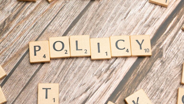 scrabble tiles spelling policy on a wooden table