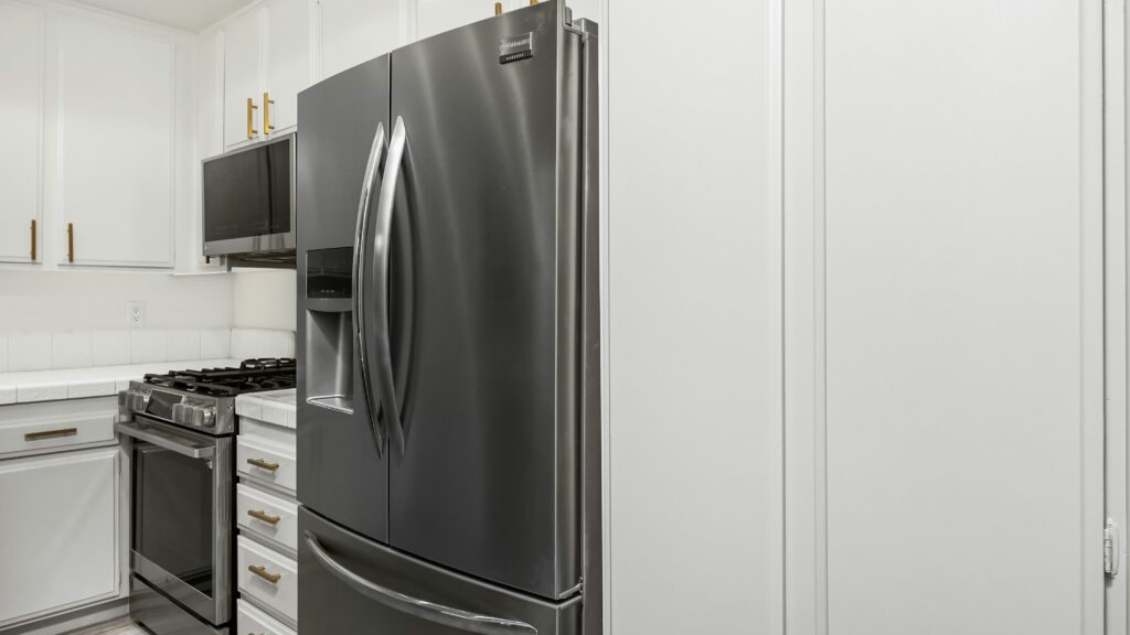 A kitchen with white cabinets and stainless steel appliances