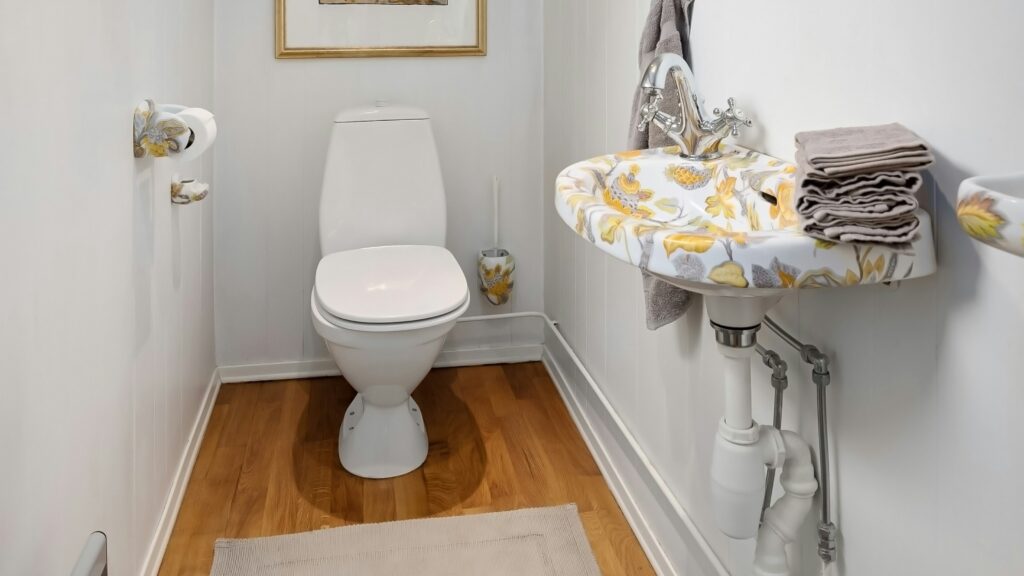 A bathroom with a toilet, sink and mirror