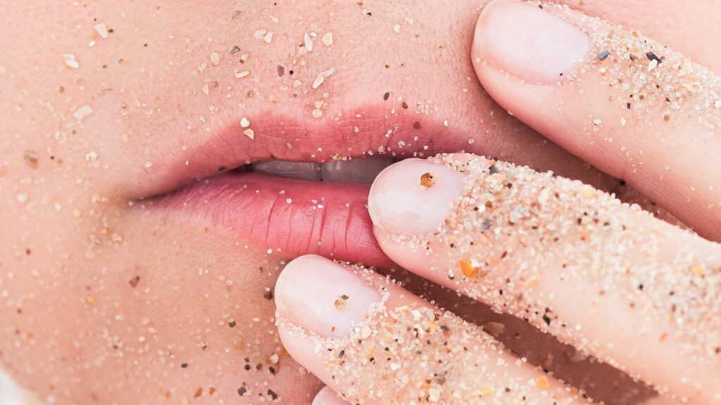 person holding lips covered in sands