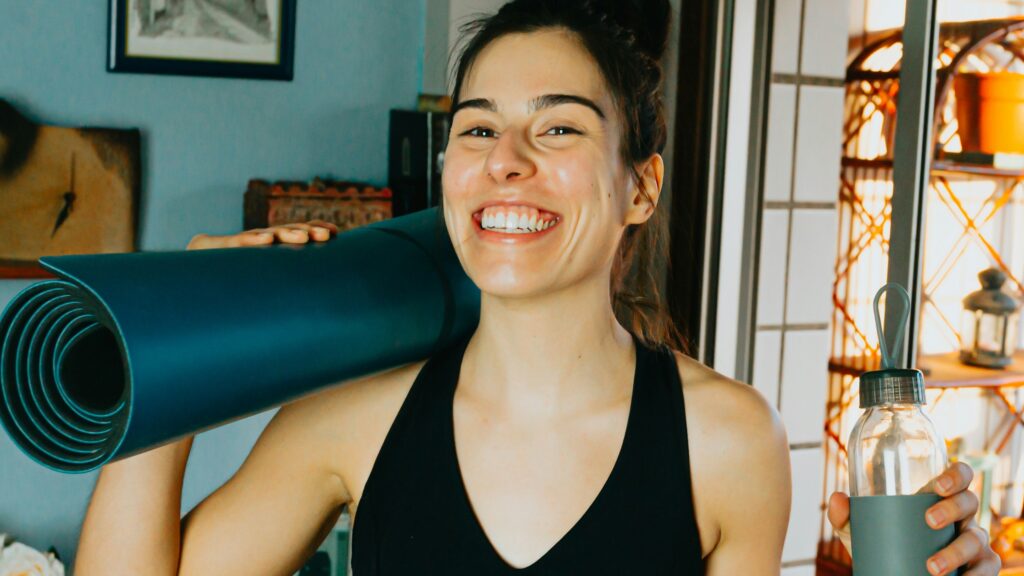 woman in black sports bra holding blue and black kettle