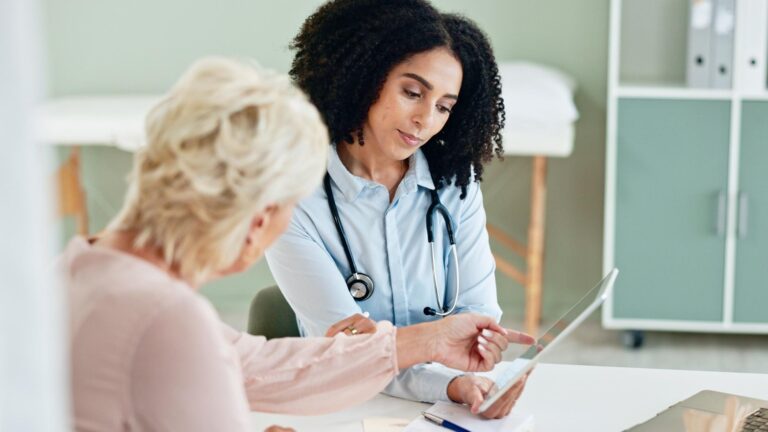 Hospital tablet and doctor with patient for consulting medical service and help in clinic Healthcare telehealth and woman and mature person on digital tech for diagnosis results and insurance