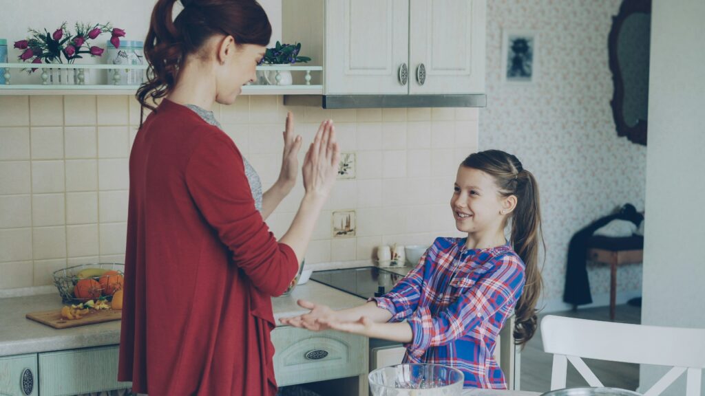 A mother and daughter are playing in the kitchen