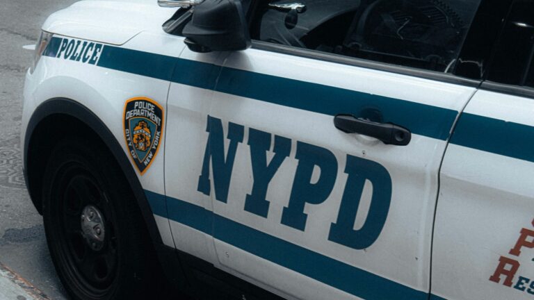 a nypd police car parked on the side of the road