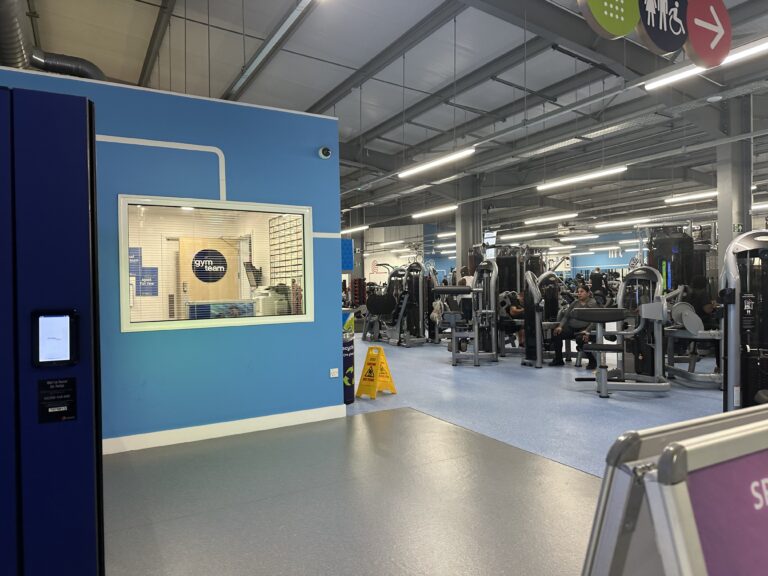 A modern gym floor with rows of exercise equipment