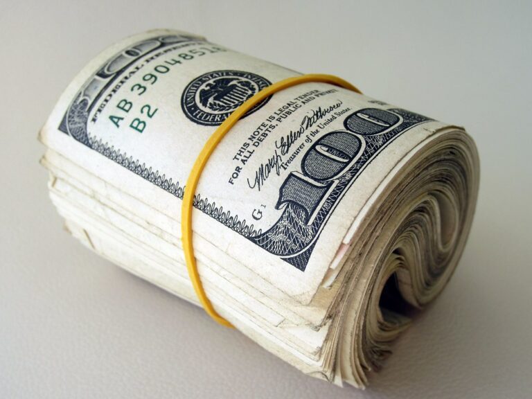 A rolled bundle of one hundred dollar bills