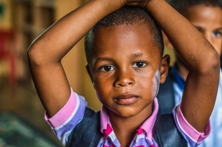 Young child wearing a backpack with a serious, worried expression