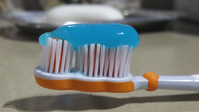 Closeup of toothpaste being squeezed onto a toothbrush