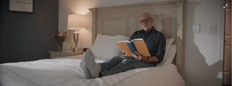 Older man reading in bed at home