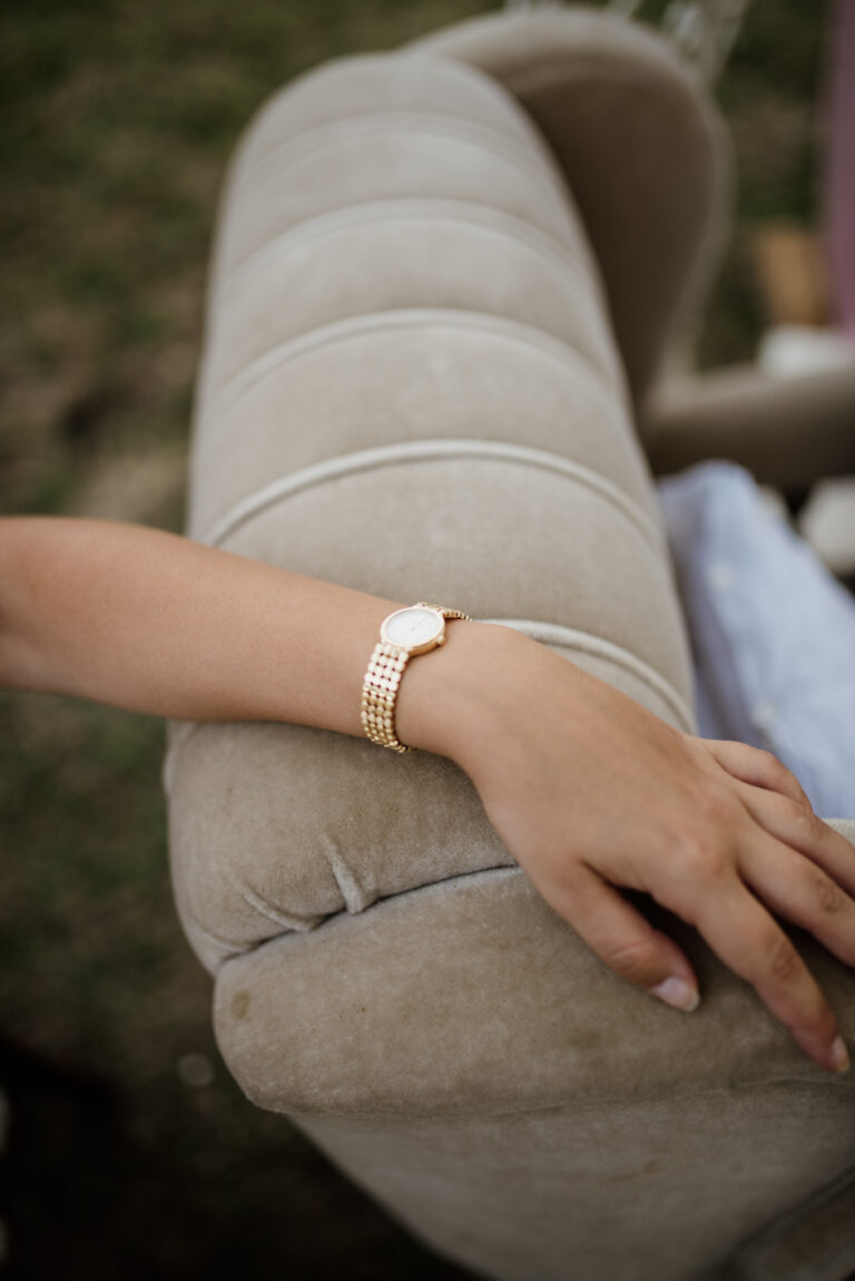 Closeup of a woman resting her hand on an armchair
